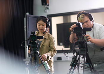 Two people running cameras