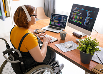 A young women on a wheelchair, programming and reading computer codes