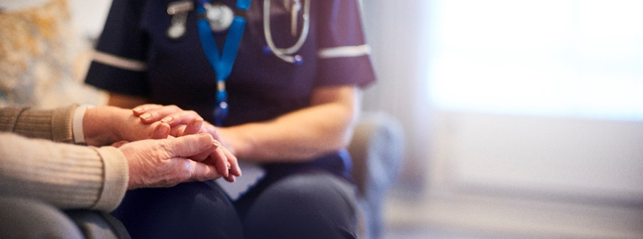 Elderly couple holding hands in a health care setting