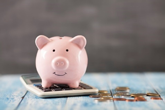 A piggy bank sitting on a calculator